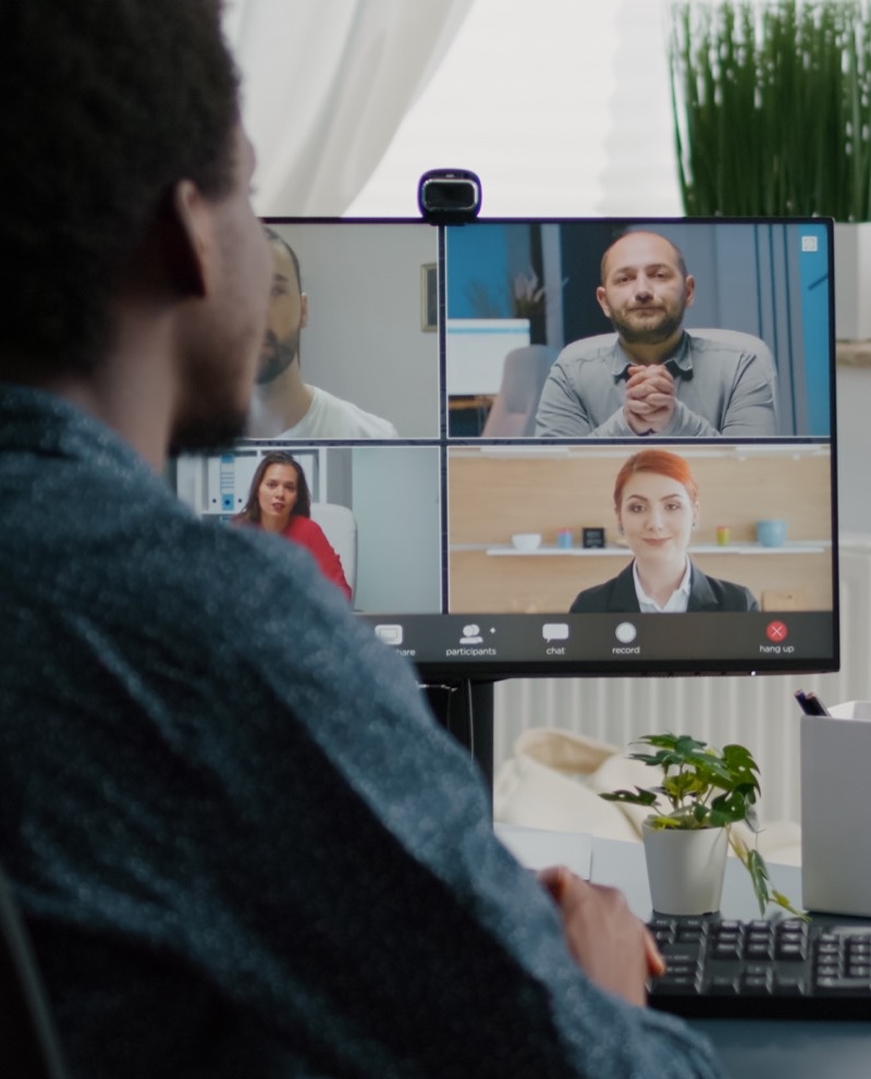 African american man waving to colleagues, talking on online conference internet call African american man waving to colleagues, talking on online conference internet call using webcam communication. Remote worker working from home keeping distance while using technology